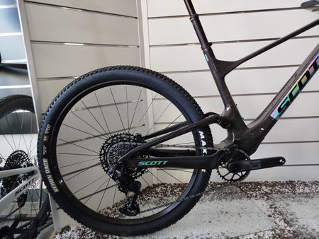 E-MTB da trail full-suspension Megamo Reason Air CRB 10 2026 in colorazione blu. Vista laterale del telaio leggero interamente in carbonio con escursione da 140 mm. In evidenza il potente motore centrale DJI Avinox, la batteria integrata da 800 Wh, la forcella Fox da 140 mm, la trasmissione Shimano XT a 12 velocità e le ruote da 29 pollici