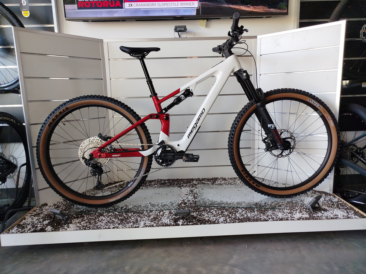 E-MTB biammortizzata Megamo Reason AL 07 nella colorazione White Red (bianco e rosso). Il telaio in alluminio idroformato mostra una sfumatura dal bianco anteriore al rosso bordeaux posteriore. In evidenza il motore DJI Avinox, la batteria integrata, la forcella Fox e le ruote da 29 pollici per e-mountain bike