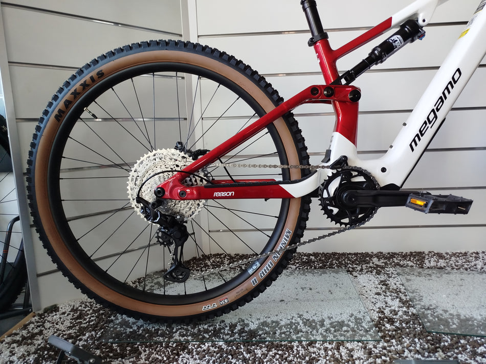 E-MTB biammortizzata Megamo Reason AL 07 nella colorazione White Red (bianco e rosso). Il telaio in alluminio idroformato mostra una sfumatura dal bianco anteriore al rosso bordeaux posteriore. In evidenza il motore DJI Avinox, la batteria integrata, la forcella Fox e le ruote da 29 pollici per e-mountain bike