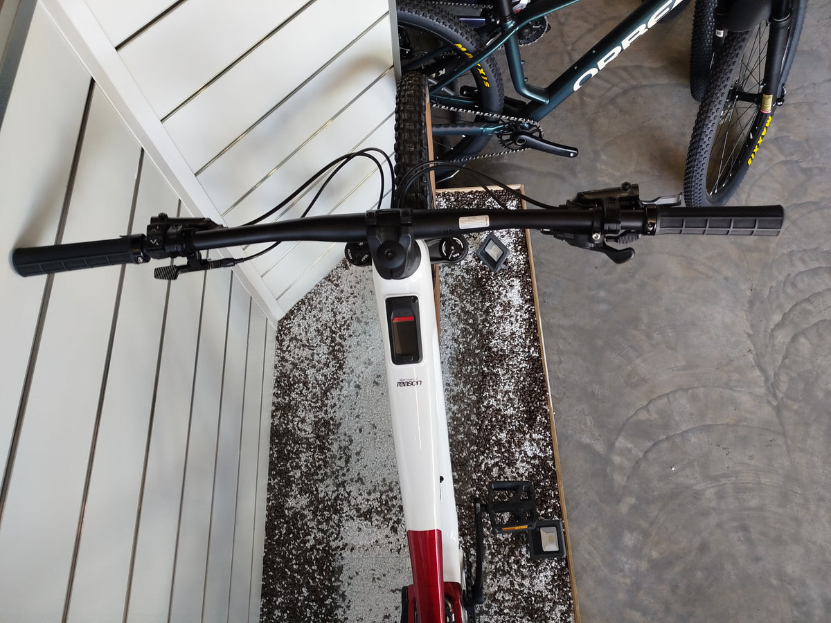 E-MTB biammortizzata Megamo Reason AL 07 nella colorazione White Red (bianco e rosso). Il telaio in alluminio idroformato mostra una sfumatura dal bianco anteriore al rosso bordeaux posteriore. In evidenza il motore DJI Avinox, la batteria integrata, la forcella Fox e le ruote da 29 pollici per e-mountain bike
