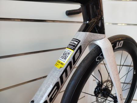 Dettaglio telaio in carbonio della bici da corsa aero Megamo Pulse 02 SLR 2026, con finitura bianca marmorizzata e scritta Megamo nera.