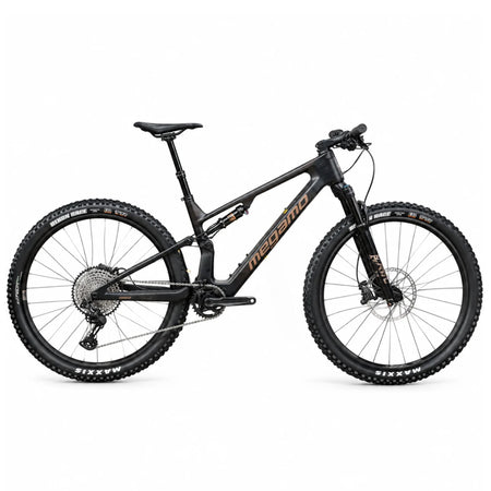 E-MTB da trail full-suspension Megamo Reason Air CRB 10 2026 in colorazione blu. Vista laterale del telaio leggero interamente in carbonio con escursione da 140 mm. In evidenza il potente motore centrale DJI Avinox, la batteria integrata da 800 Wh, la forcella Fox da 140 mm, la trasmissione Shimano XT a 12 velocità e le ruote da 29 pollici